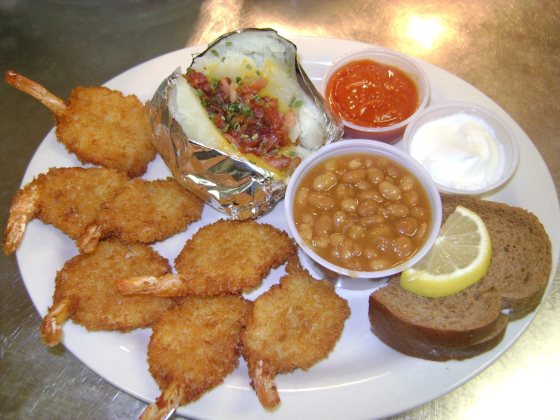 Seven jumbo fantail shrimp with a loaded baked potato, baked beans, cocktail sauce, sour cream, lemon and rye bread.