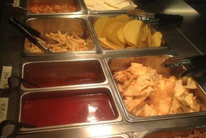 The taco and wing buffet line: wings, soft tortillas, seasoned beef, fries, tortilla chips, sauces and nacho cheese in steam-table pans.